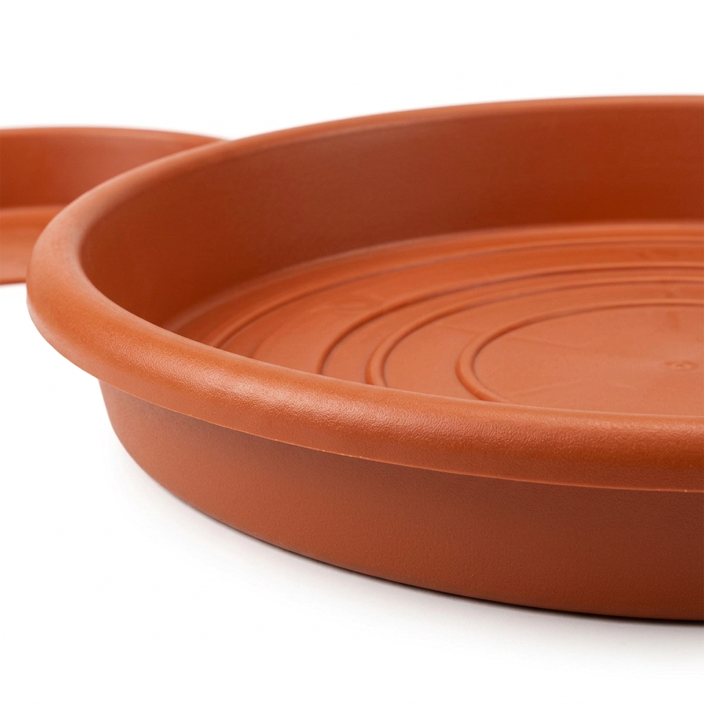 Macro side view of terracotta plastic plant saucer showing raised rim depth profile and base structure on pure white background