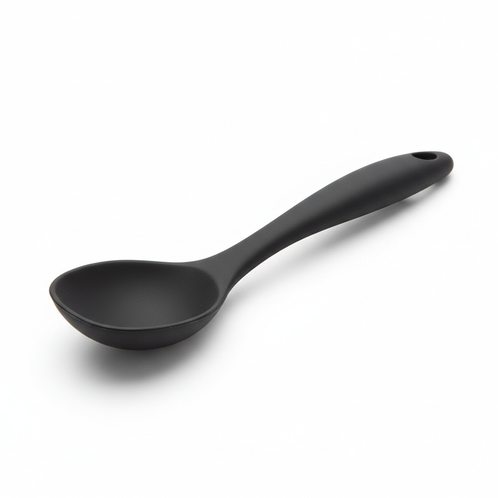 Matte black one-piece silicone cooking spoon with hanging hole on pure white background