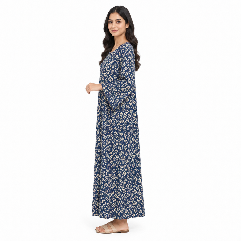 Side view of model in the full-length navy botanical print kaftan dress showing its loose sleeve and drape on white