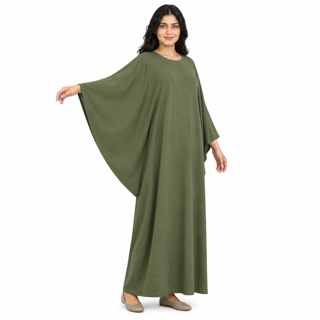 Three-quarter view of model wearing an olive kaftan dress with one batwing sleeve extended to show the curved underarm drape on white