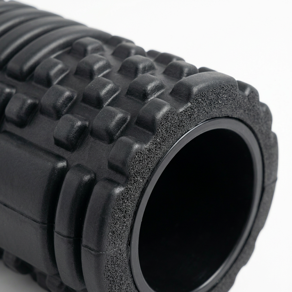Detail close-up of foam roller 3D textured grid pattern and inner PVC core on white background
