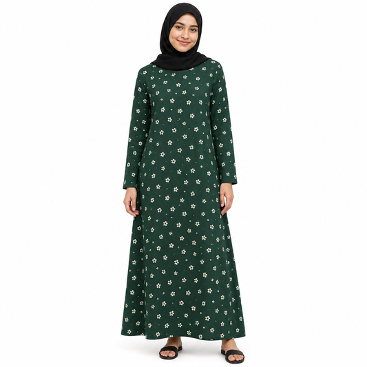 Model in a black hijab wearing a dark green A-line maxi dress with small cream floral print and long sleeves on a white background