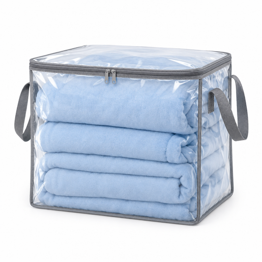 Blanket storage bag, clear PEVA zippered quilt bag with gray binding and handles holding a folded blanket on white background