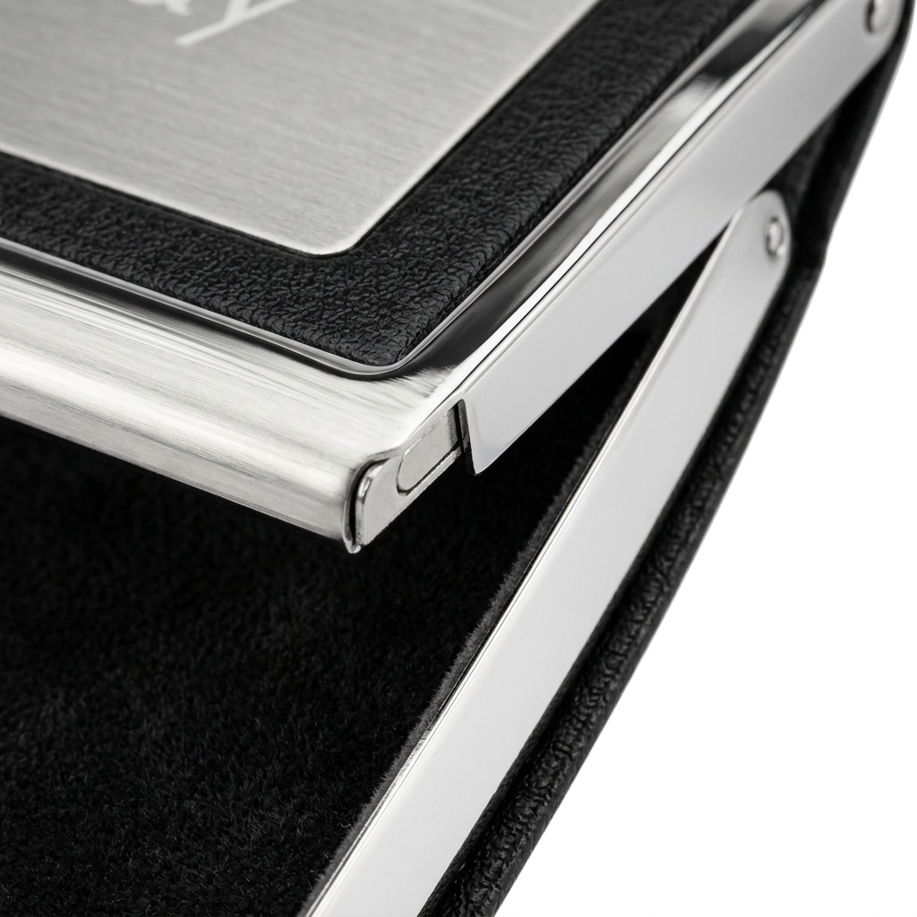 Detail close-up of business card holder showing brushed stainless steel lid, magnetic seal, and velvet lining on white background