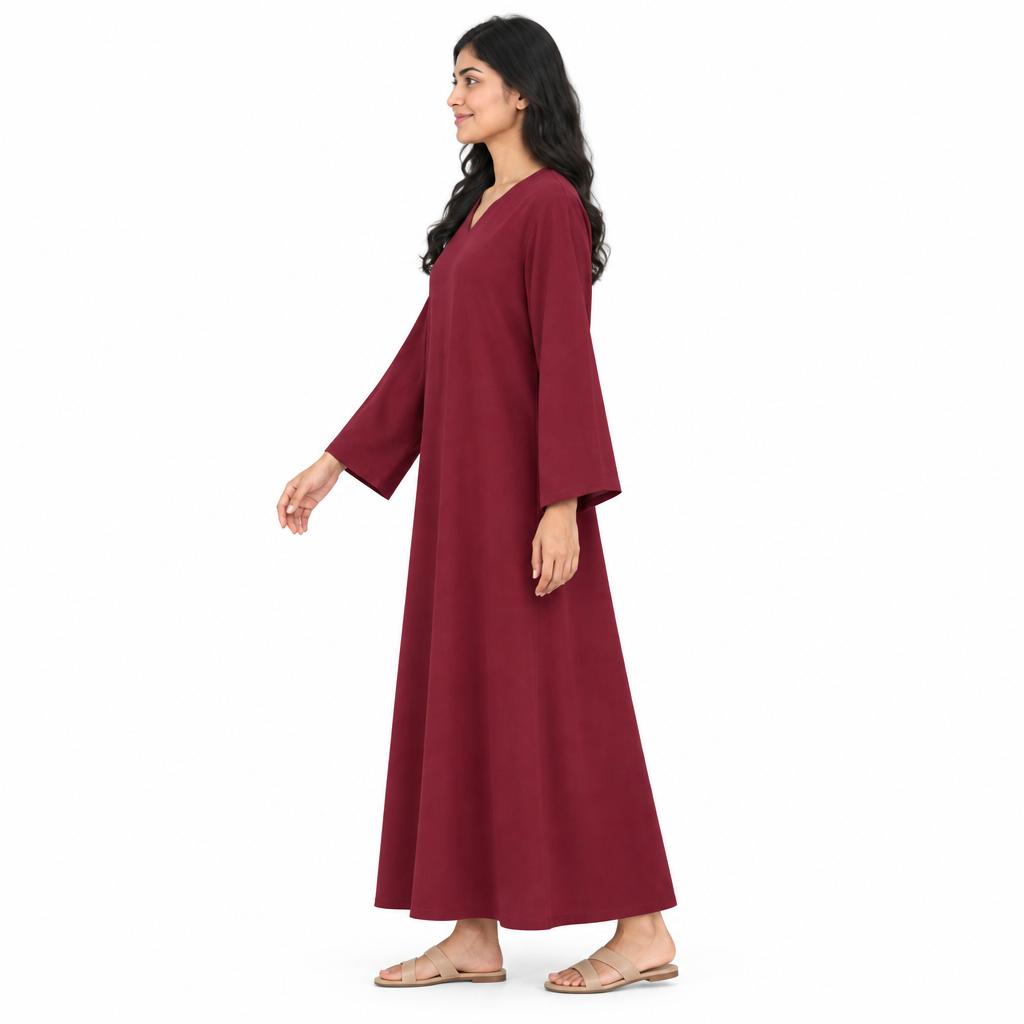 Side profile of model wearing a plain burgundy loose V-neck kaftan dress with wide long sleeve on white