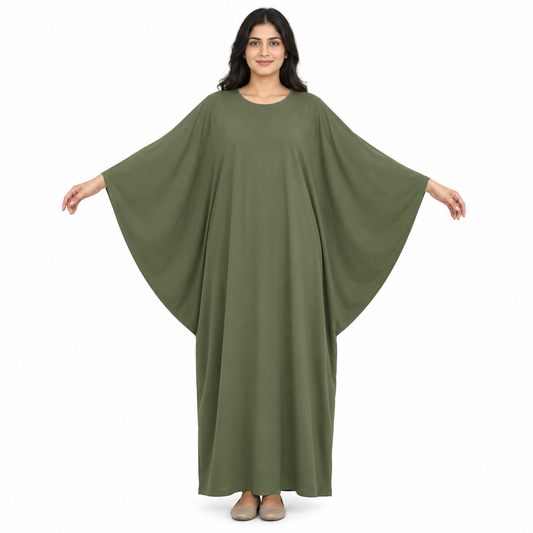 Front view of model with arms out showing wide integrated batwing sleeves on a full-length plain olive kaftan dress against white
