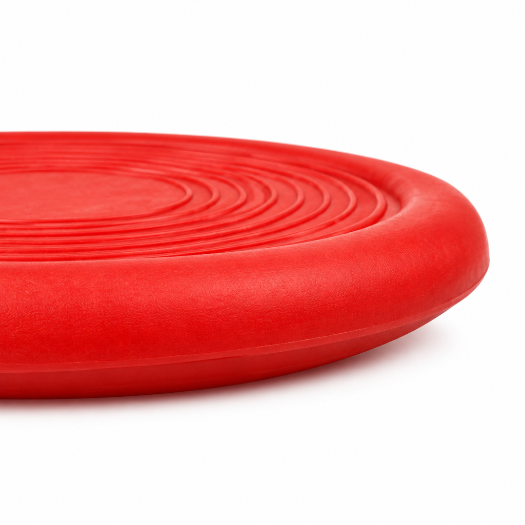 Side profile close-up detail of flexible dog flying disc showing contoured rubber rim thickness on pure white background