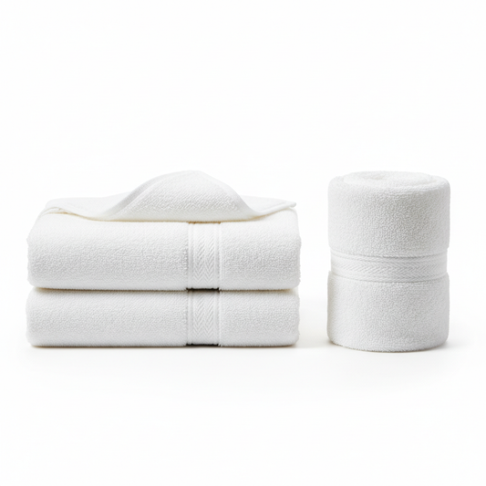 White cotton terry hotel bath towel shown folded in rectangular stack and rolled cylinder with edge folded back showing dense terry loop pile texture and dobby border weave on white background, 500 GSM commercial hospitality bath linen