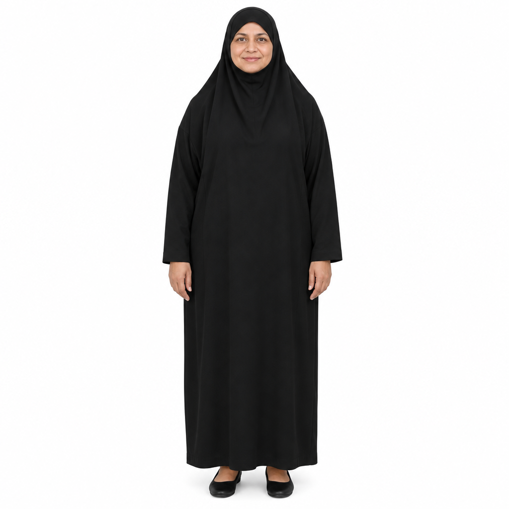Mature model wearing a plain black one-piece loose jilbab dress with attached head covering and full-length body on a white background