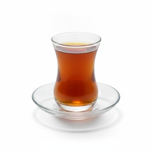 Traditional clear Arabic tea glass with amber tea on matching saucer on pure white background