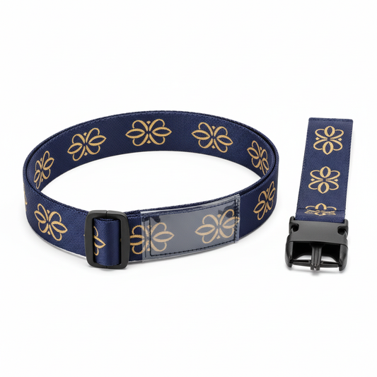 Navy adjustable hotel luggage strap with woven gold motif, side-release buckle, tri-glide adjuster, reinforced stitching and identification sleeve on white background