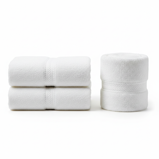 Thick white premium combed cotton hotel luxury bath towel folded in heavy rectangular stack and rolled cylinder with corner showing ultra-dense terry loop pile and jacquard dobby border weave on white background, 600 GSM premium hospitality bath linen