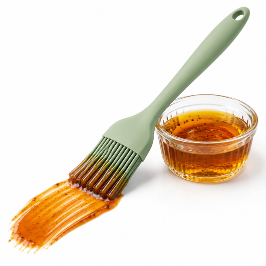 Seamless food-grade silicone basting brush loaded with barbecue sauce and showing a smooth glaze streak on a pure white background