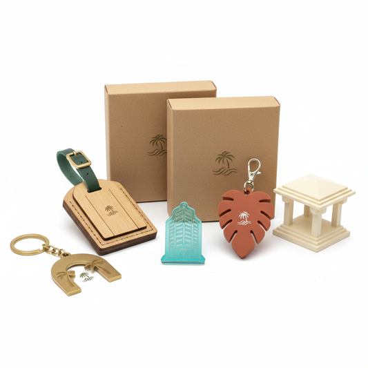 Hotel souvenir assortment with metal keychain, wood luggage-tag ornament, acrylic magnet, silicone bag charm, resin resort miniature and kraft boxes