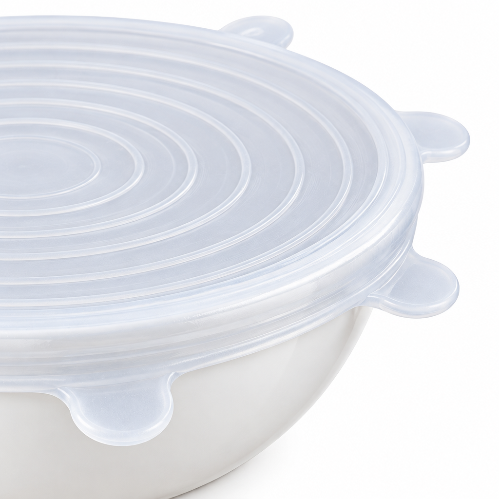 Close-up of flexible silicone food cover edge with grip tabs stretched over a white ceramic bowl rim