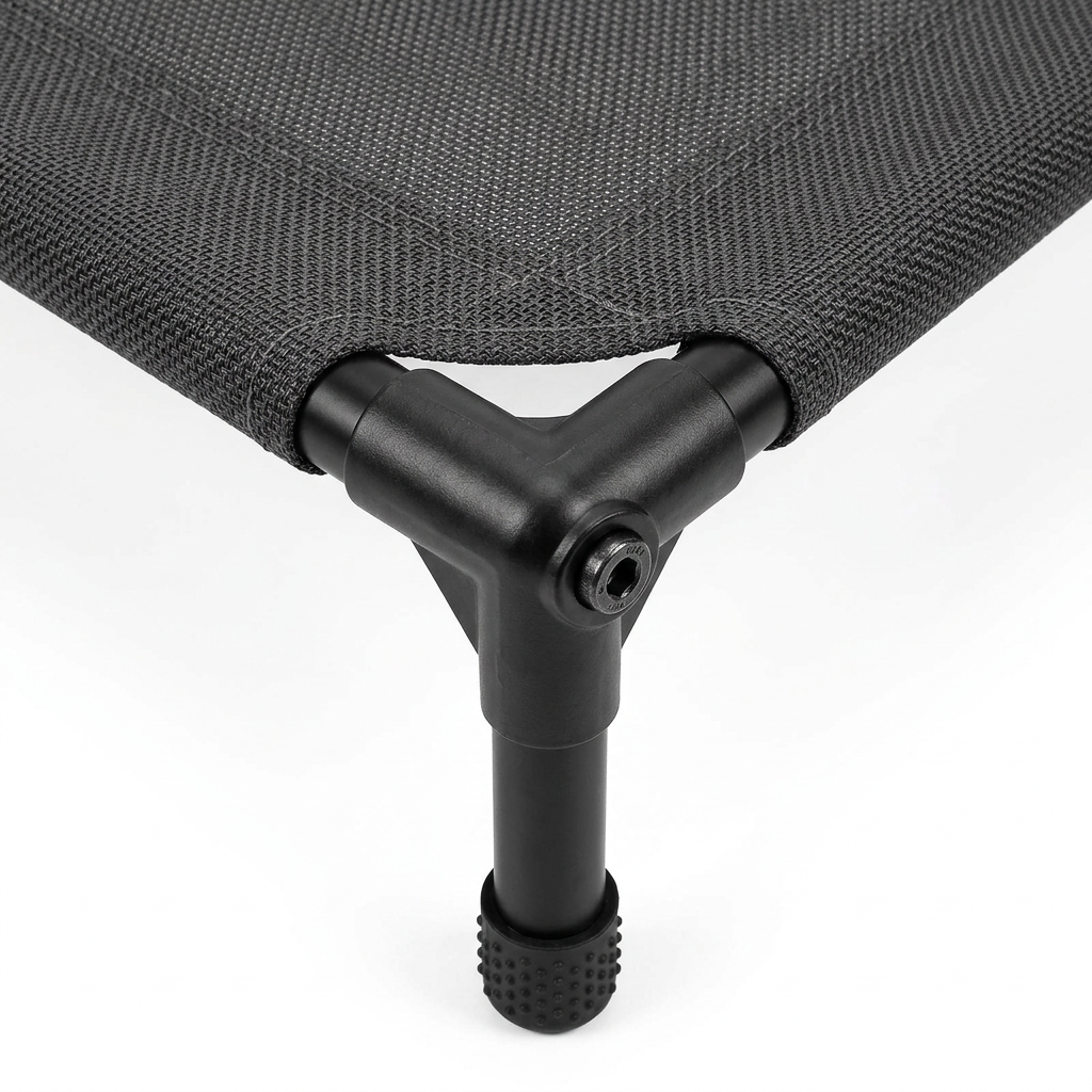 Close-up detail of elevated dog bed corner joint, steel tube sleeve, woven mesh fabric, and rubber skid-resistant foot