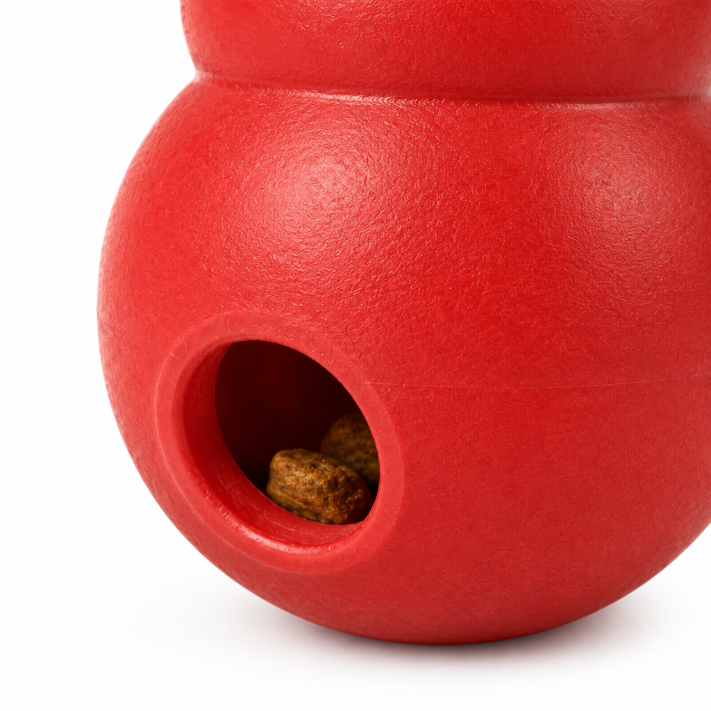 Macro close-up detail of treat-dispensing hole and thick rubber cavity wall with dry kibble
